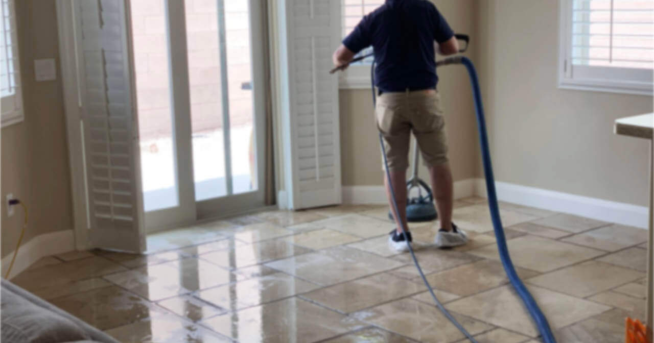 Man scrubbing tiles with a machine to clean the floor and grout in saint george, ut